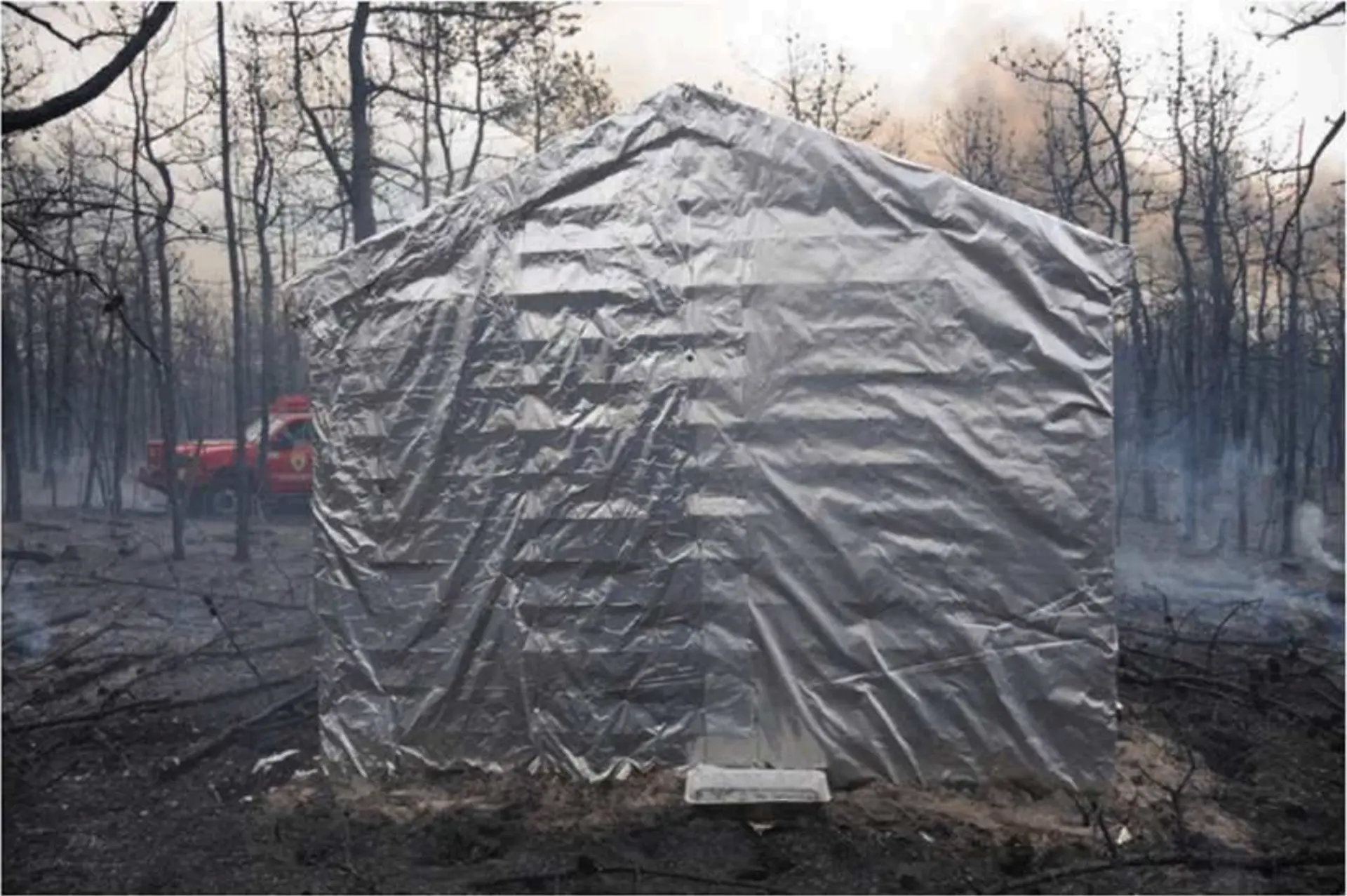 A structure wrapped in aluminized FireFoil shielding during a wildfire deployment